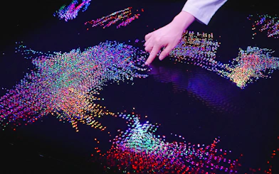 Interactive digital art display at Team Lab Abu Dhabi with colorful lights and hand interaction.