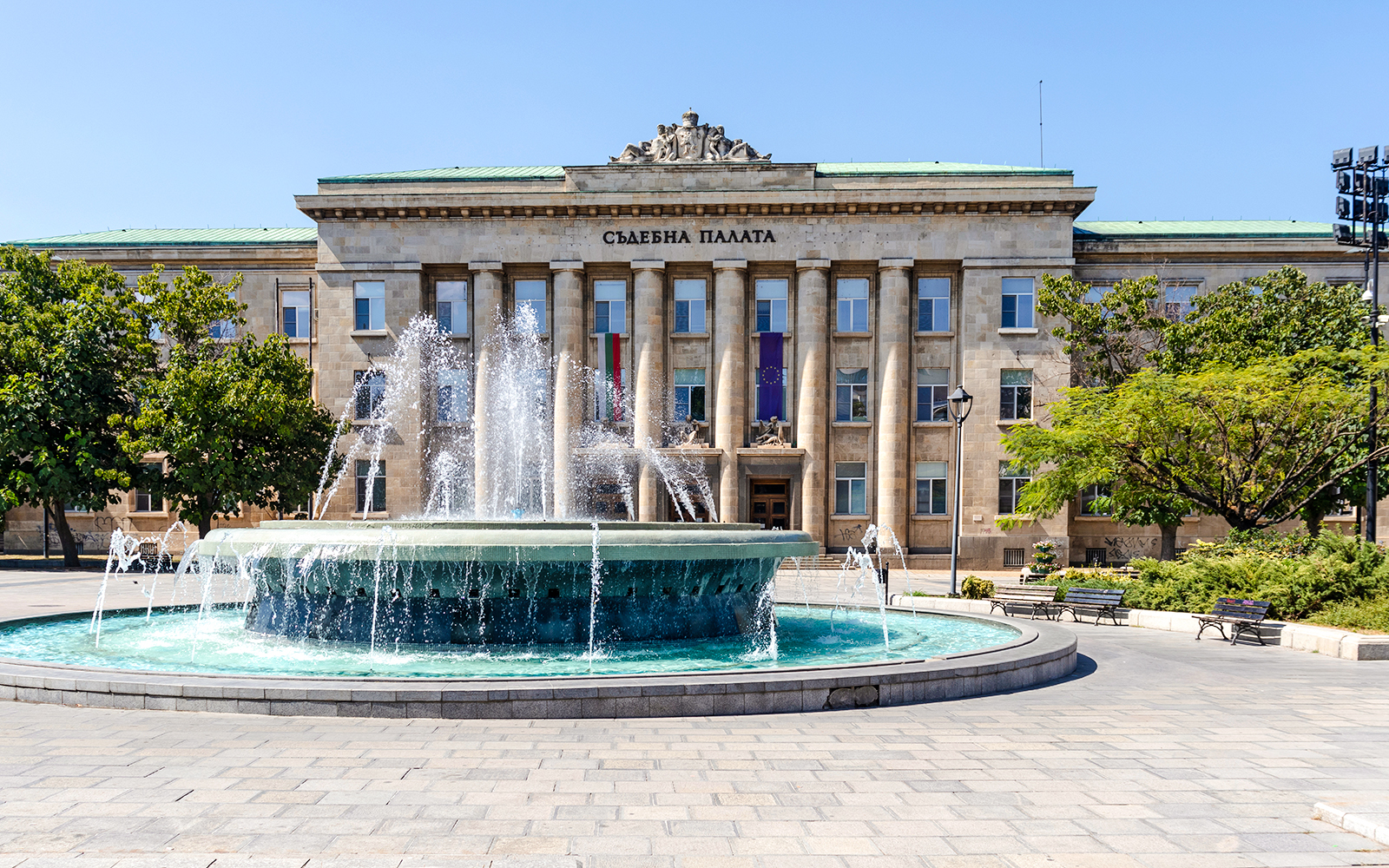 Courthouse in Ruse, Bulgaria with a fountain in front.