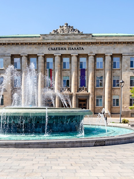 Courthouse in Ruse, Bulgaria with a fountain in front.