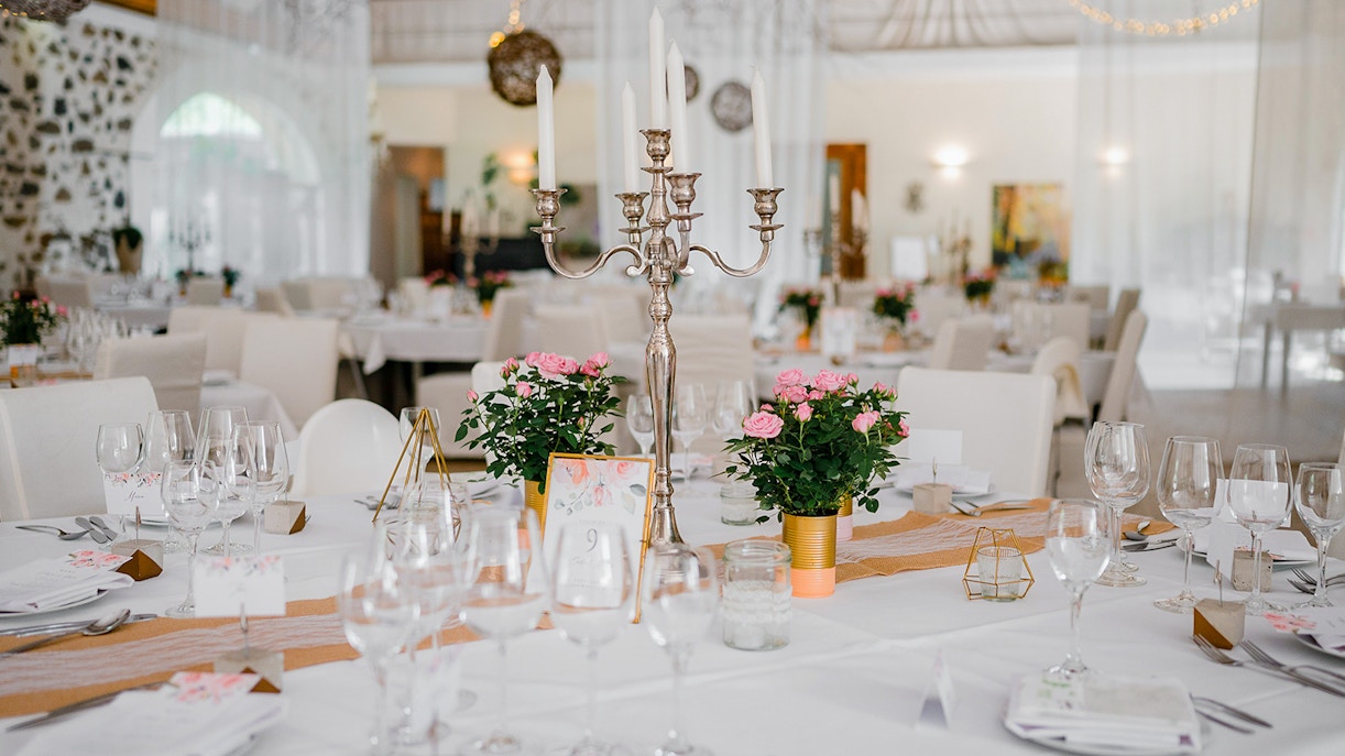 Castle dining room with long wooden table and ornate chandeliers.