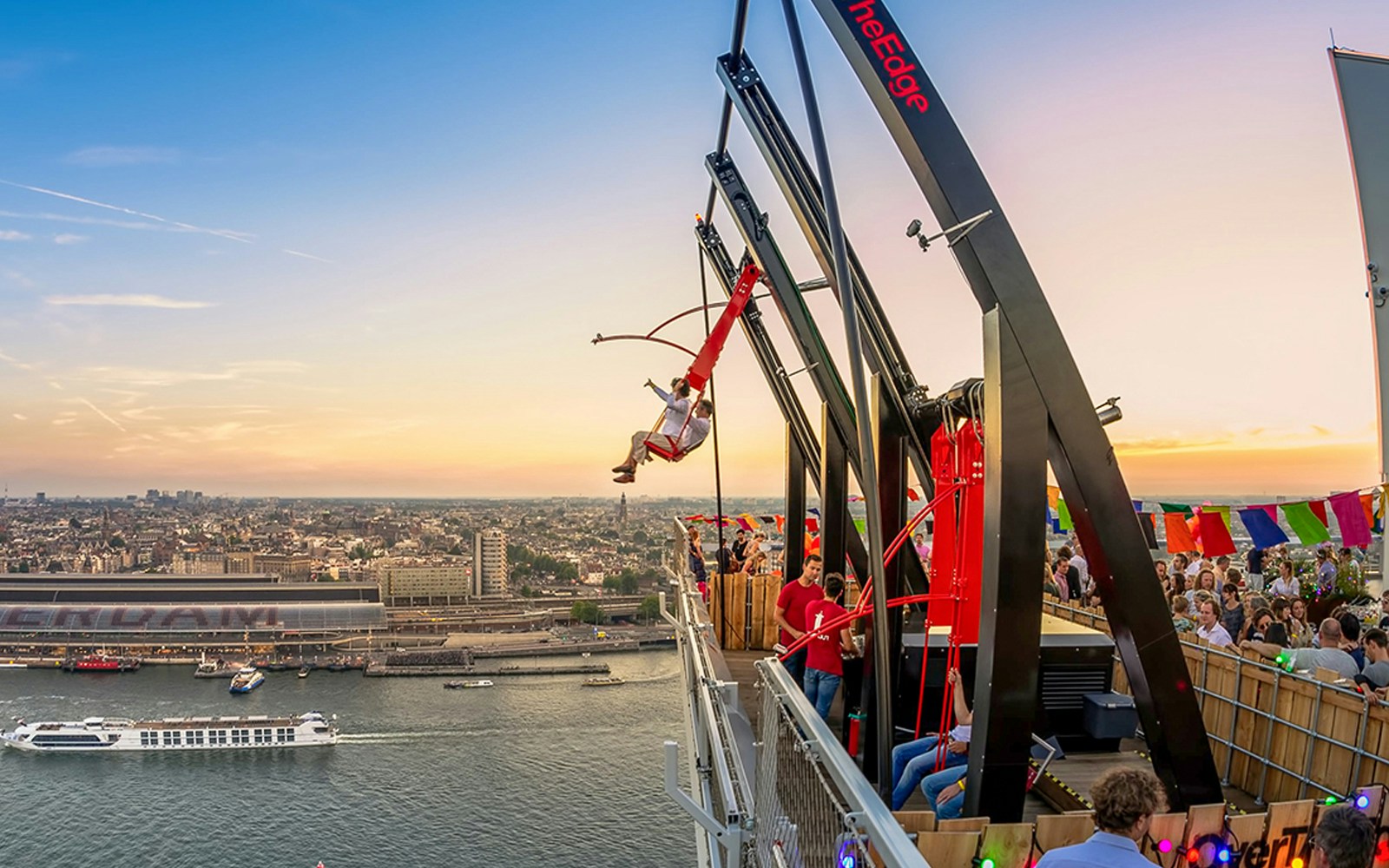 Tourists on swing ride at A'DAM LOOKOUT with Amsterdam skyline in the background.