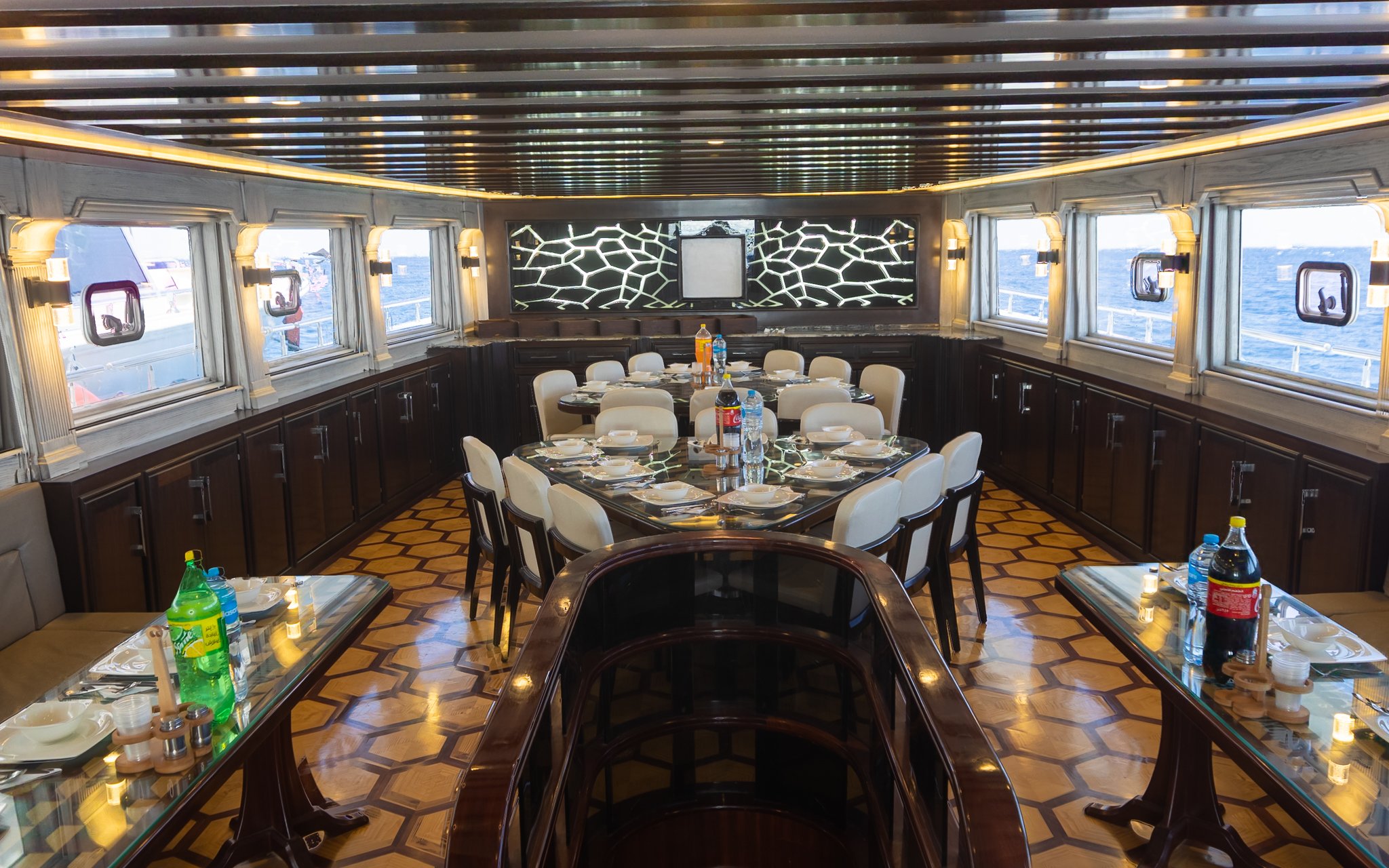 Interior saloon and dining area of a yacht, Orange Bay Island, Hurghada, with set dining tables.