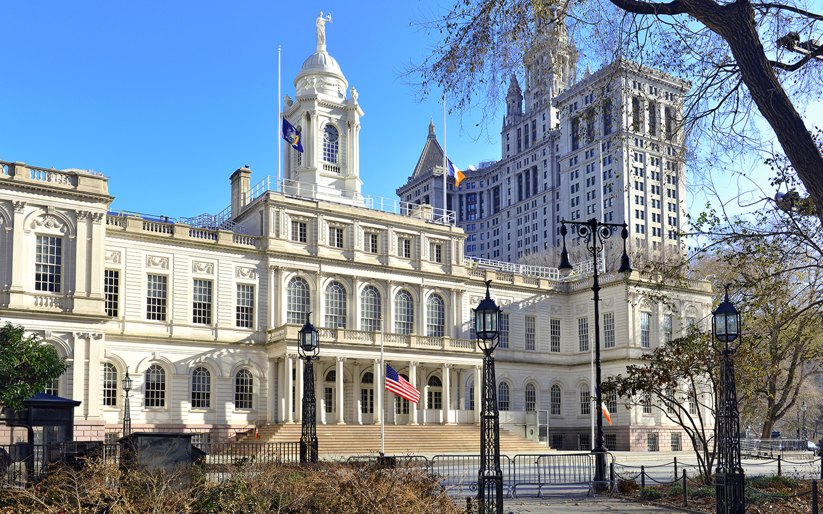 New York City Hall with American flag and surrounding architecture.