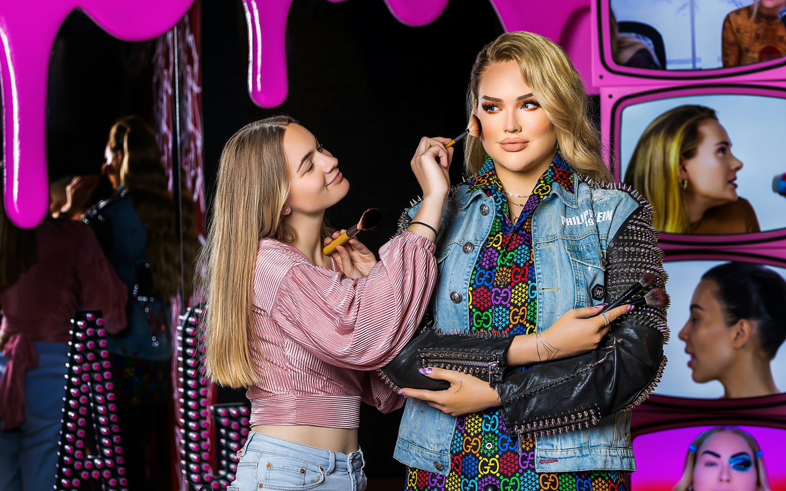 Makeup artist applying blush to wax figure at Madame Tussauds Amsterdam.