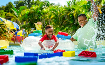 Child enjoying Lazy River with floating LEGO bricks at Legoland Florida Water Park.