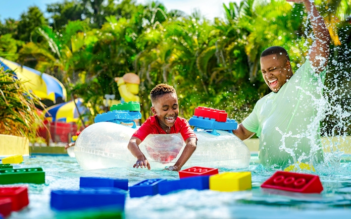 Child enjoying Lazy River with floating LEGO bricks at Legoland Florida Water Park.