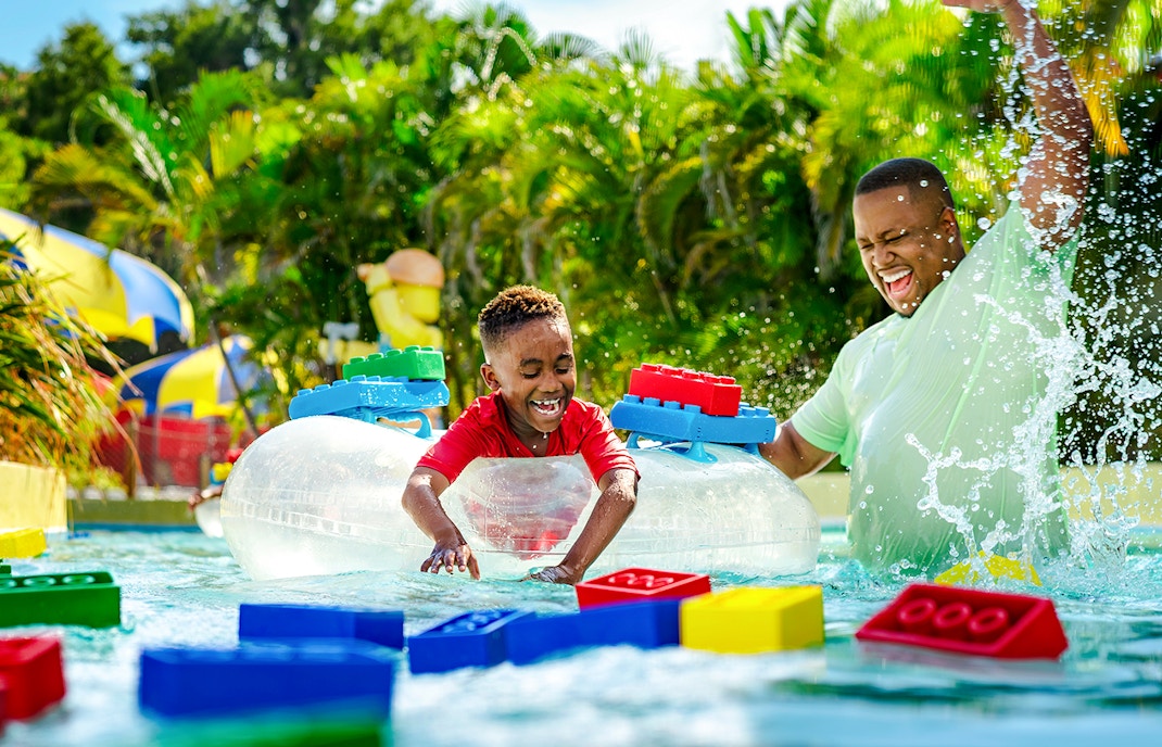 Child enjoying Lazy River with floating LEGO bricks at Legoland Florida Water Park.