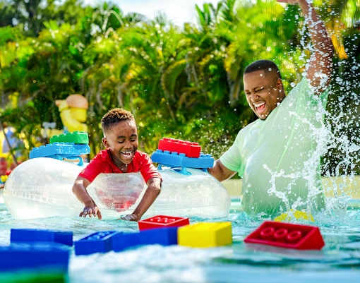 Child enjoying Lazy River with floating LEGO bricks at Legoland Florida Water Park.