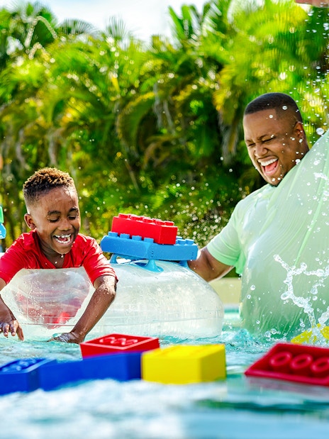 Child enjoying Lazy River with floating LEGO bricks at Legoland Florida Water Park.