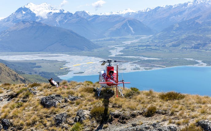 Helicopter landing on alpine terrain with mountain and river views, Milford Sound tour from Queenstown.