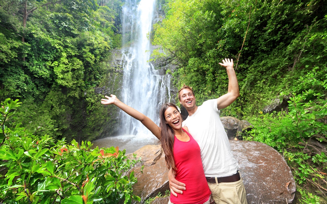 Couple enjoying a waterfall on the Premium Road to Hana tour, Maui, Hawaii.