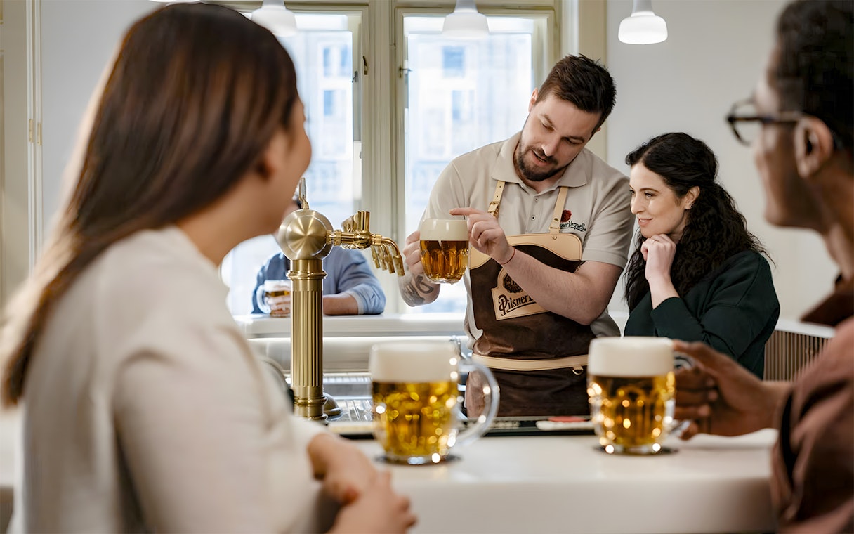 Tapster demonstrating beer pouring technique at Pilsner Urquell experience.