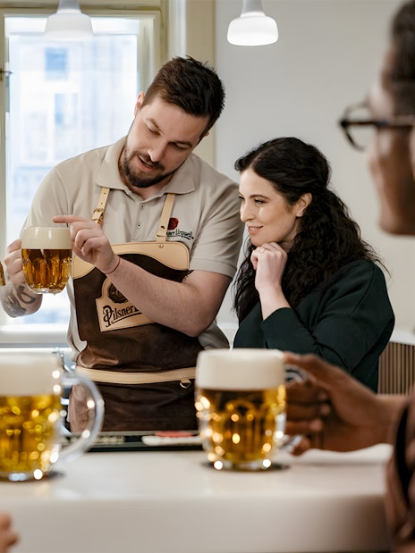 Tapster demonstrating beer pouring technique at Pilsner Urquell experience.