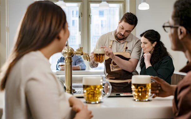 Tapster demonstrating beer pouring technique at Pilsner Urquell experience.