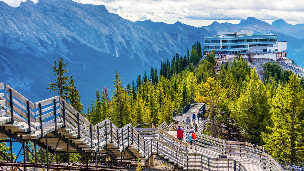 Guests walking on wooden boardwalk to summit station, Sulphur Mountain, Banff.