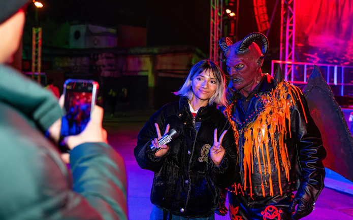 Person posing with a demon character at Thorpe Park Fright Nights.