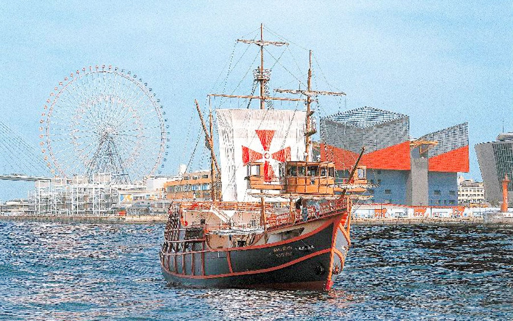 Santa Maria cruise ship in Osaka Bay with Tempozan Ferris Wheel and Osaka Aquarium Kaiyukan.