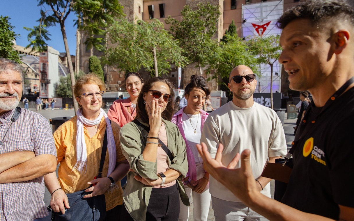 Tourists listening to a guide during a walking tour in Barcelona.