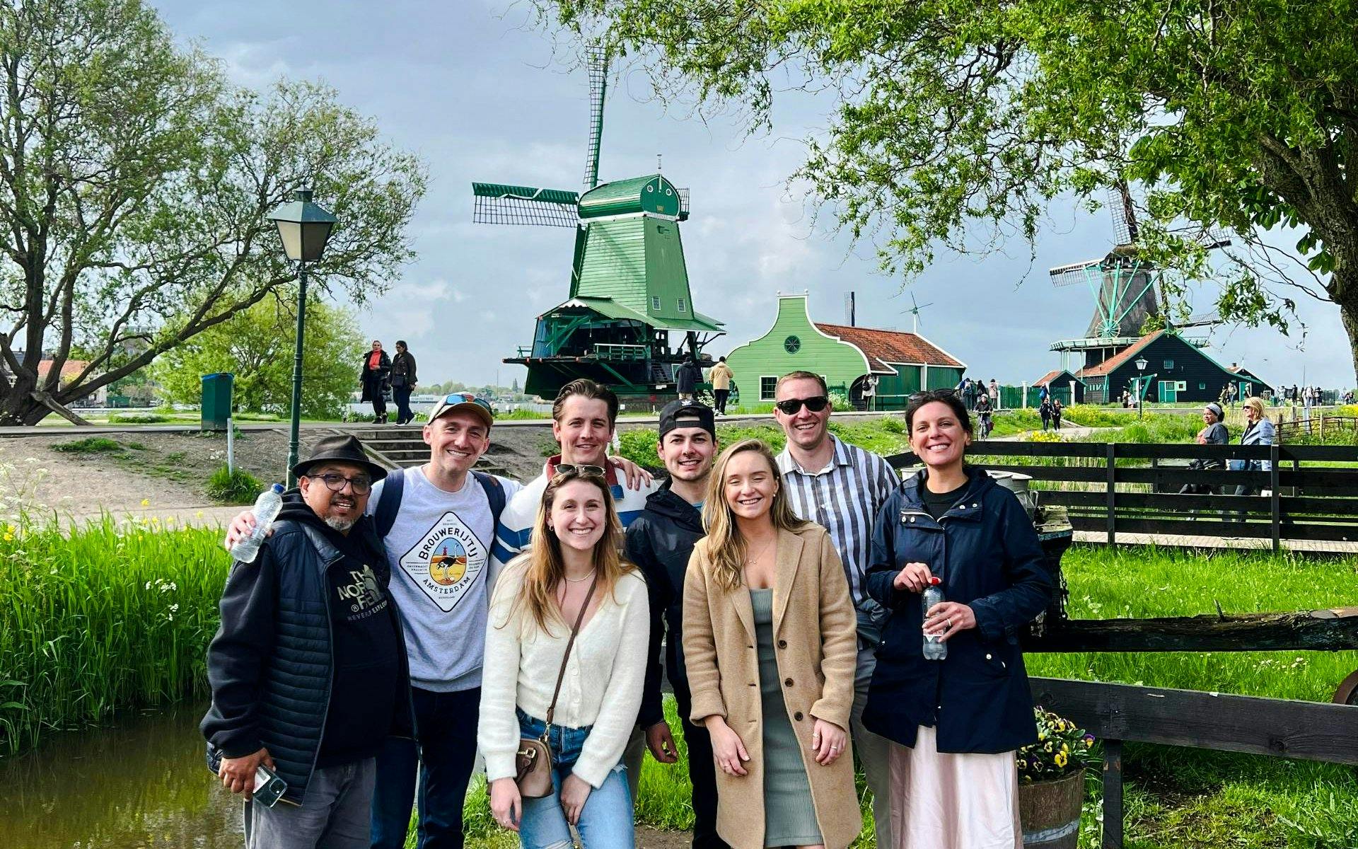 Guests enjoying the Zaanse Schans tour with windmills in the background.