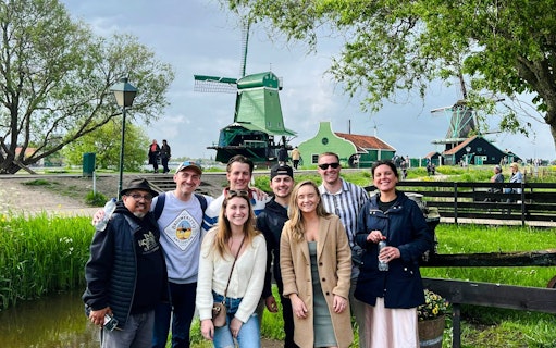 Guests enjoying the Zaanse Schans tour with windmills in the background.