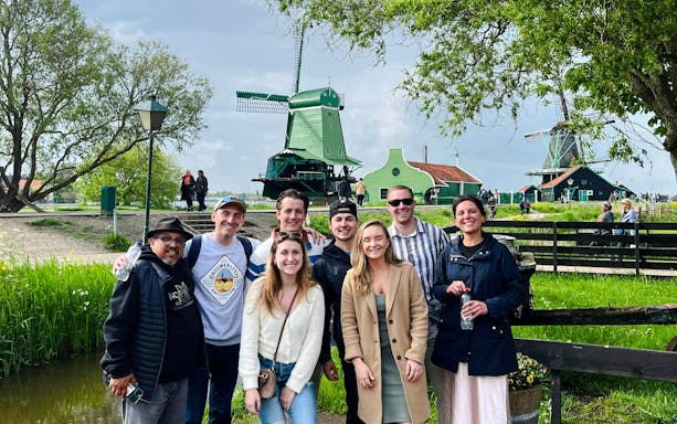Guests enjoying the Zaanse Schans tour with windmills in the background.