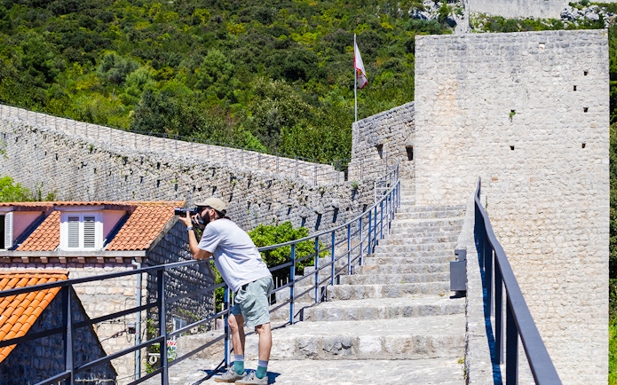 Visitor photographing Ston walls in Croatia.