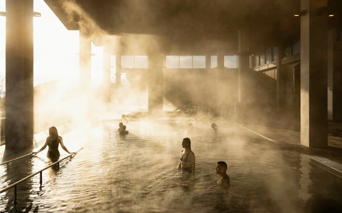 Visitors enjoying mineral bathing in the steamy Hydropool at Wai Ariki Hot Springs, Rotorua.