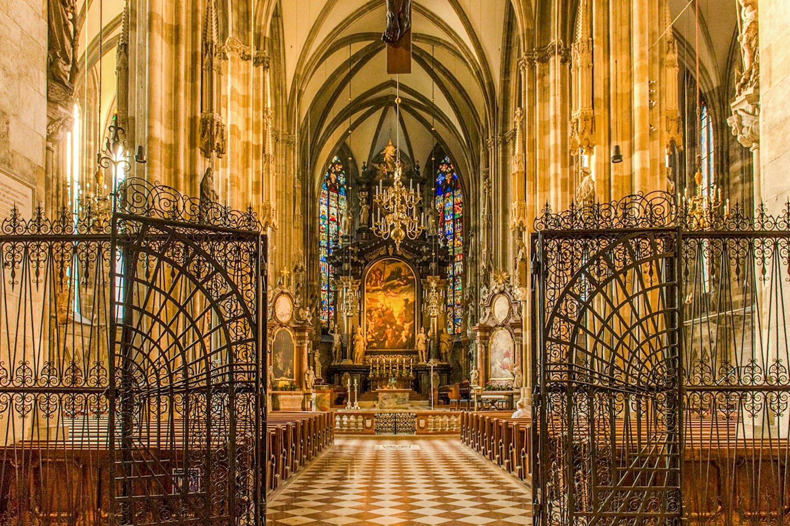 Interior view of St. Stephen's Cathedral in Vienna, featuring ornate gates and stained glass windows.