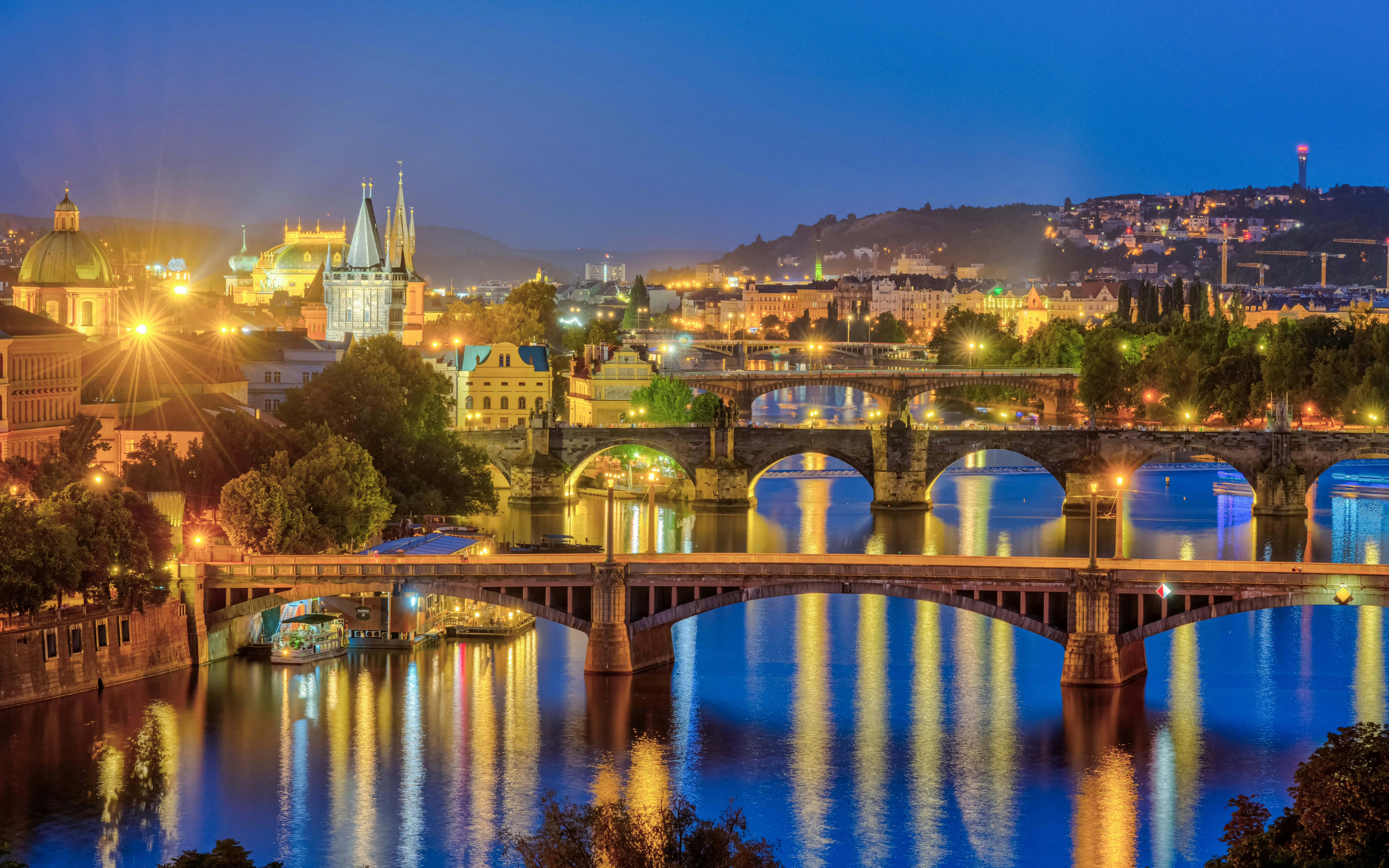 Prague's illuminated bridges over the Vltava River at night.