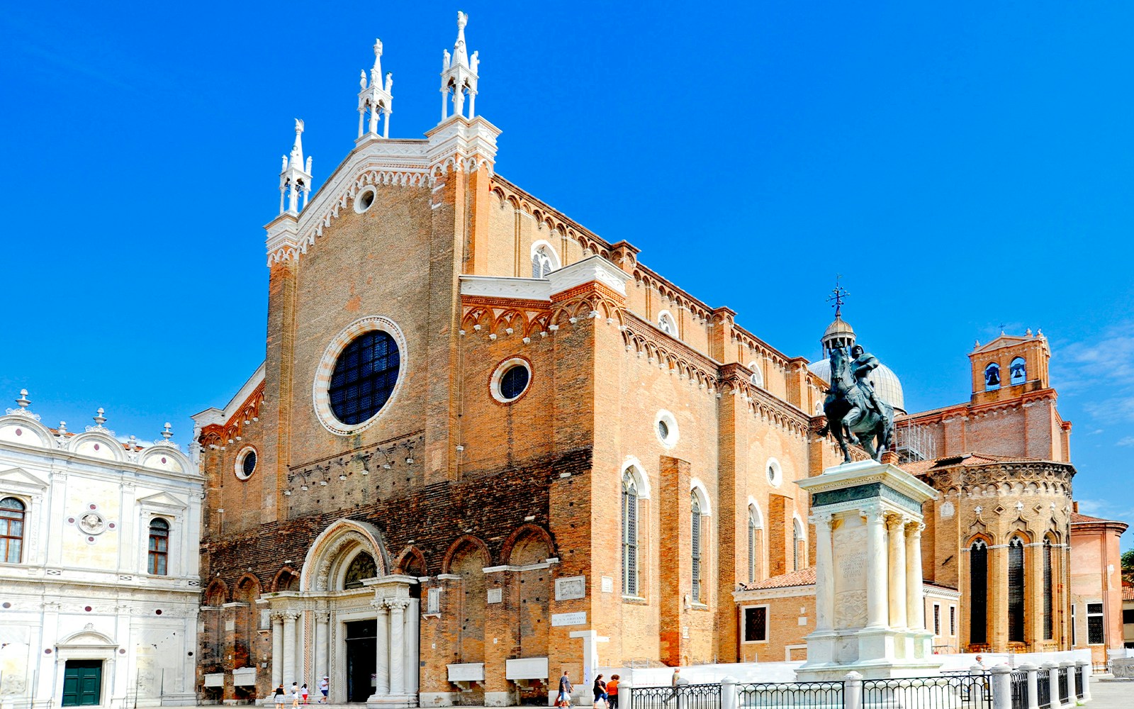 Santi Giovanni e Paolo Church in Venice with brick facade and bustling square.