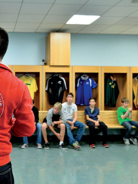 Guide leading a tour group in the Stade de France locker room, Paris.