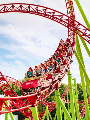Roller coaster with riders on a red and green track at Six Flags Over Georgia.