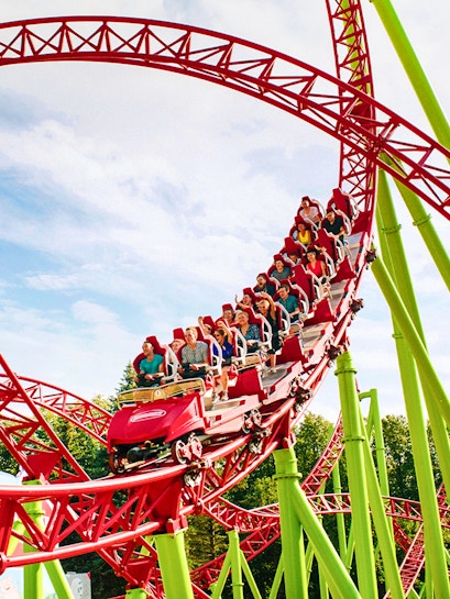 Roller coaster with riders on a red and green track at Six Flags Over Georgia.