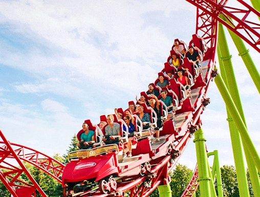 Roller coaster with riders on a red and green track at Six Flags Over Georgia.