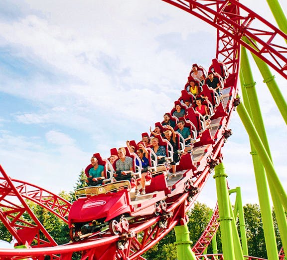 Roller coaster with riders on a red and green track at Six Flags Over Georgia.