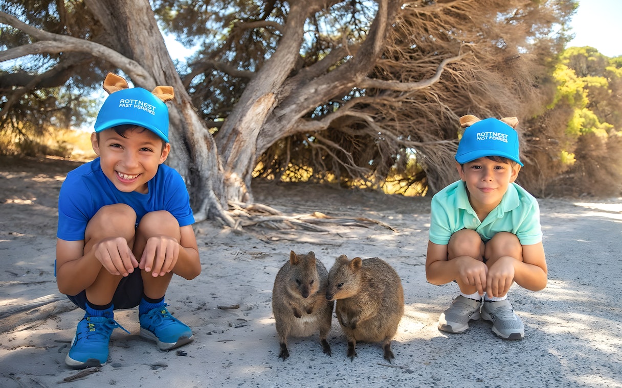 Children crouching near quokkas on Rottnest Island during a guided bus tour.