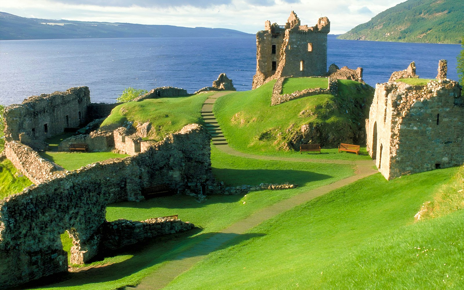 Urquhart Castle ruins overlooking Loch Ness on a sunny day, part of Inverness day tour.
