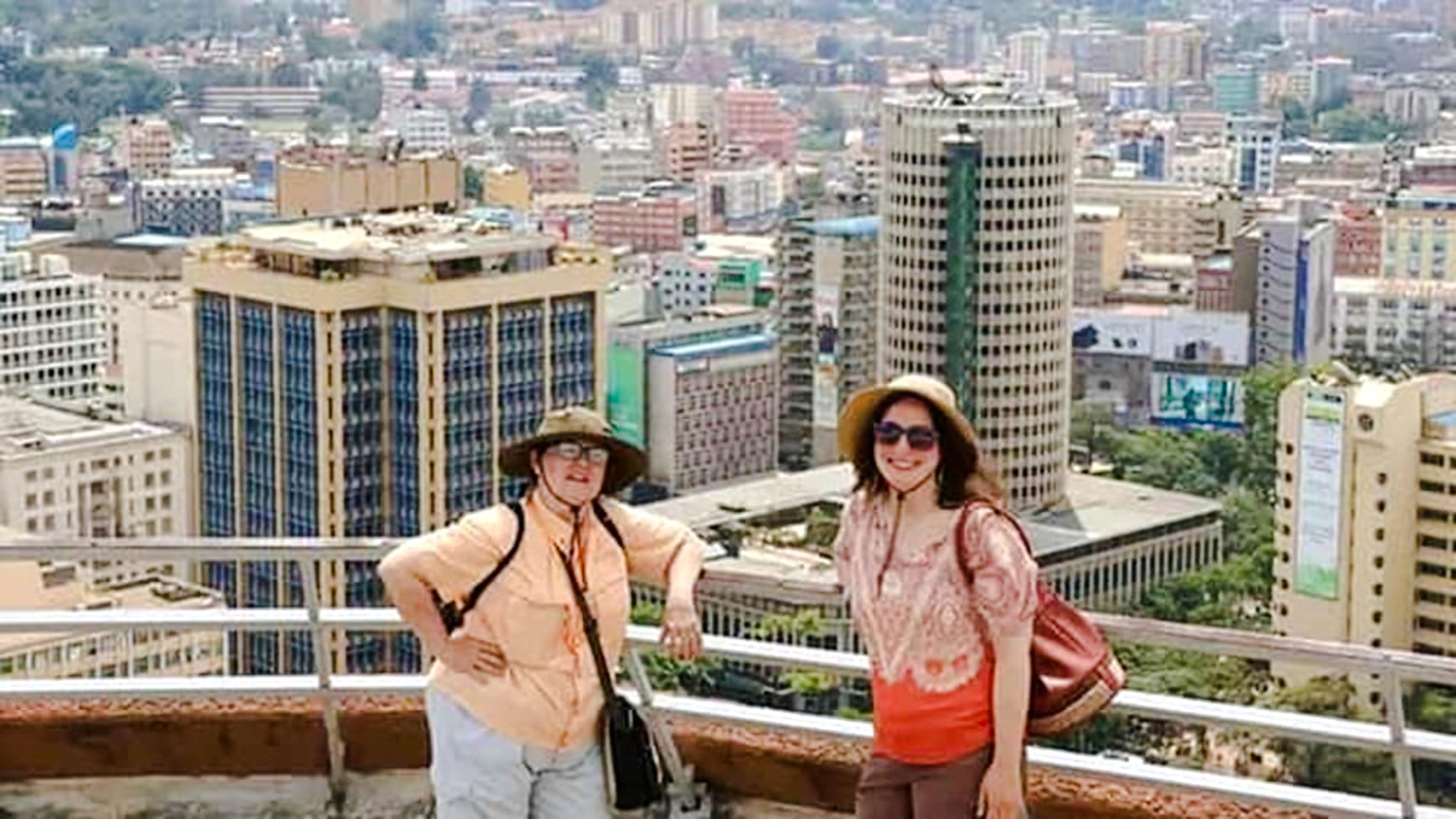Tourists enjoying a rooftop view of Nairobi's skyline during a city orientation walking tour.