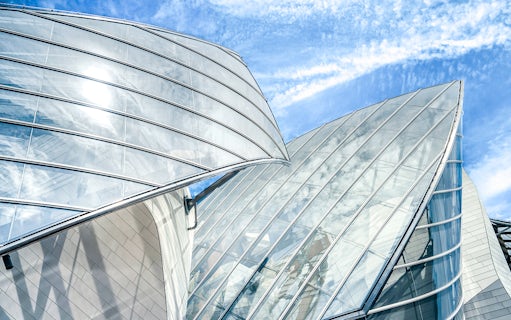 Fondation Louis Vuitton's glass architecture under a blue sky in Paris.