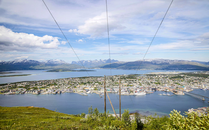 Tromso cityscape and fjord view from Storsteinen mountain ledge, Norway.