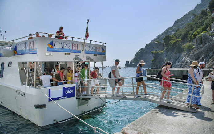Tourists disembarking from a cruise ship at Amalfi Coast dock.