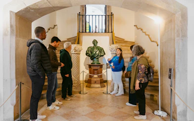 Tour group listening to a guide near a statue inside Pena Palace.