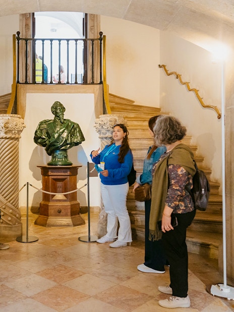 Tour group listening to a guide near a statue inside Pena Palace.