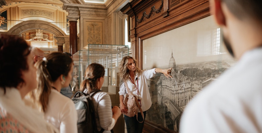 Tour guide explaining artwork to visitors in the Vatican Museums.