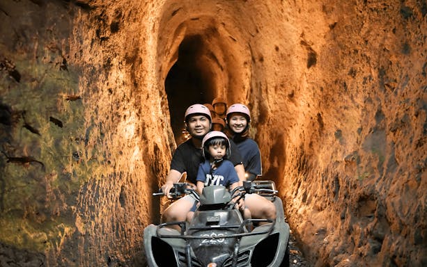 Guests riding an ATV quad bike through a tunnel in Ubud.