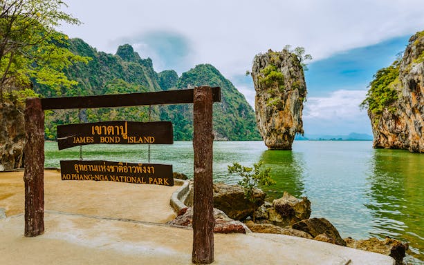James Bond Island sign with limestone karst in Ao Phang Nga National Park, Thailand.