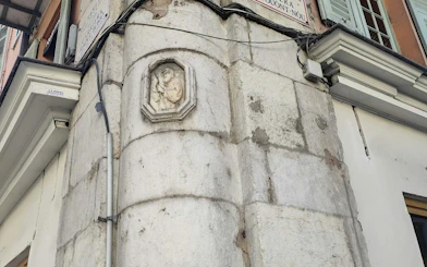 Stone relief on a building corner in Nice, part of the Murder Mystery City Exploration Game.