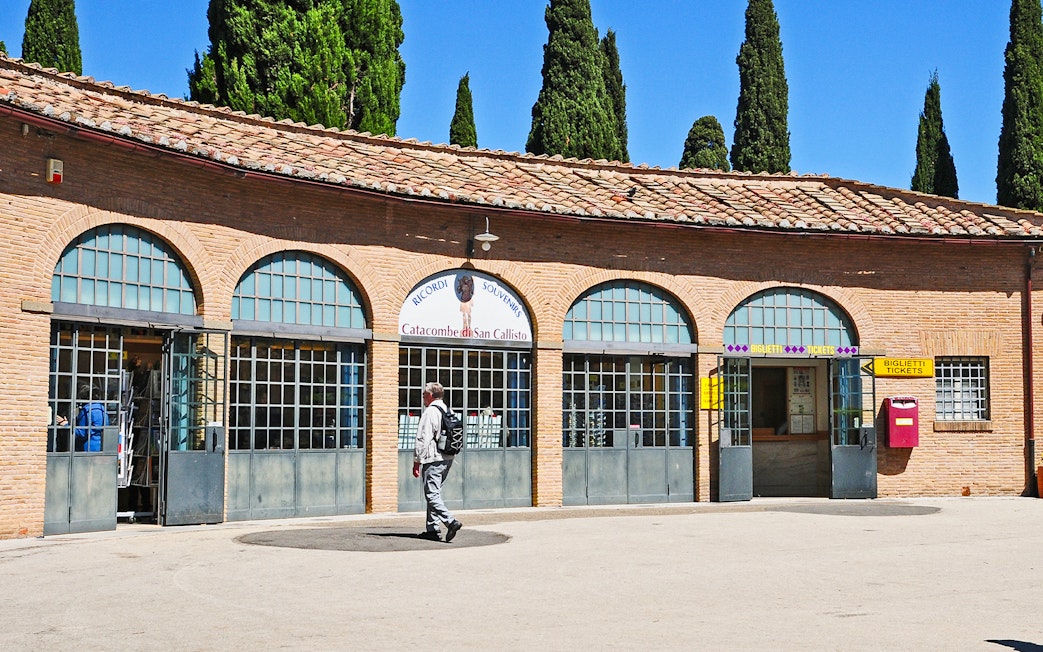 Tourist entering ticket office for Catacombs of St. Callixtus in Rome.