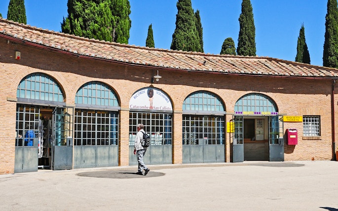 Tourist entering ticket office for Catacombs of St. Callixtus in Rome.