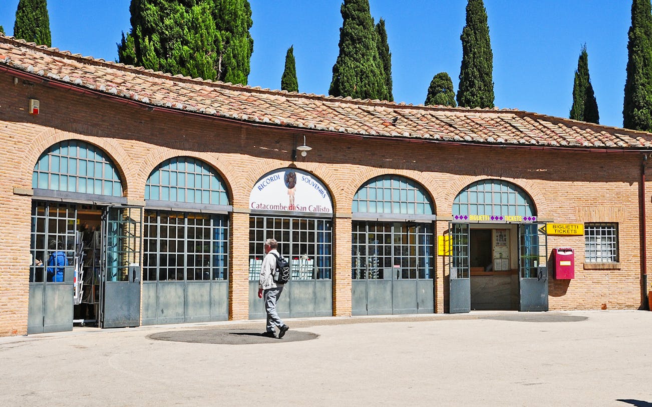 Tourist entering ticket office for Catacombs of St. Callixtus in Rome.